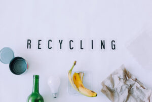 Texto "Recycling" junto a algunos residuos reciclables, haciendo referencia al Día Mundial del Reciclaje