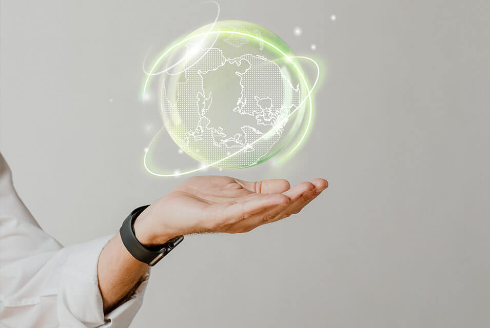 Mano de hombre con reloj y camisa blanca, sosteniendo una ilustración digital de un planeta Tierra color verde, una consecuencia del uso de los Criterios ESG
